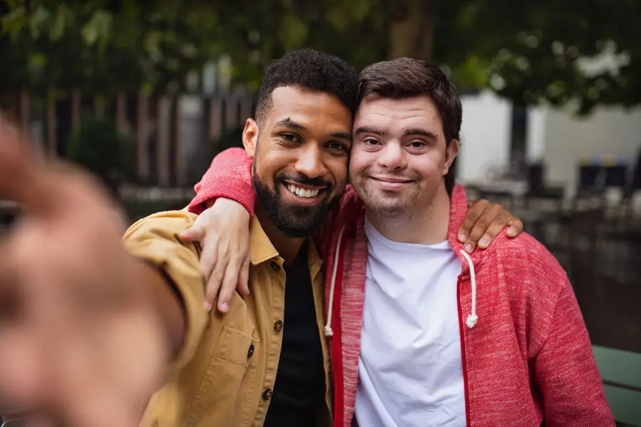 Two friends enjoying the companionship provided by NDIS Support Services Melbourne during an outdoor activity.