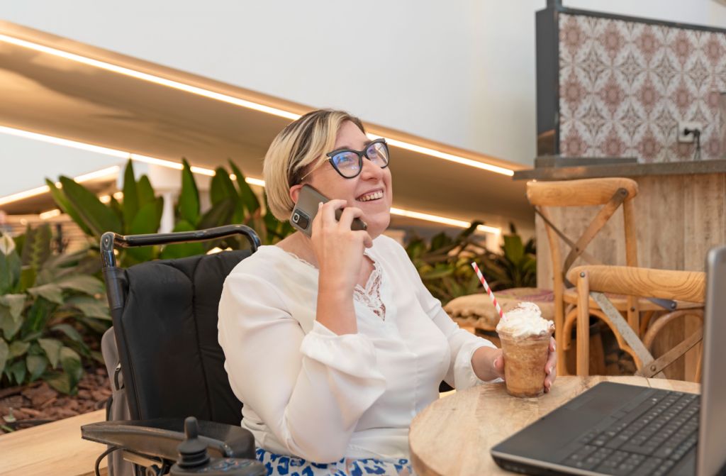 A person in a wheelchair making a phone call, representing what is an NDIS service provider and how they enable individuals to stay connected and manage their services independently.