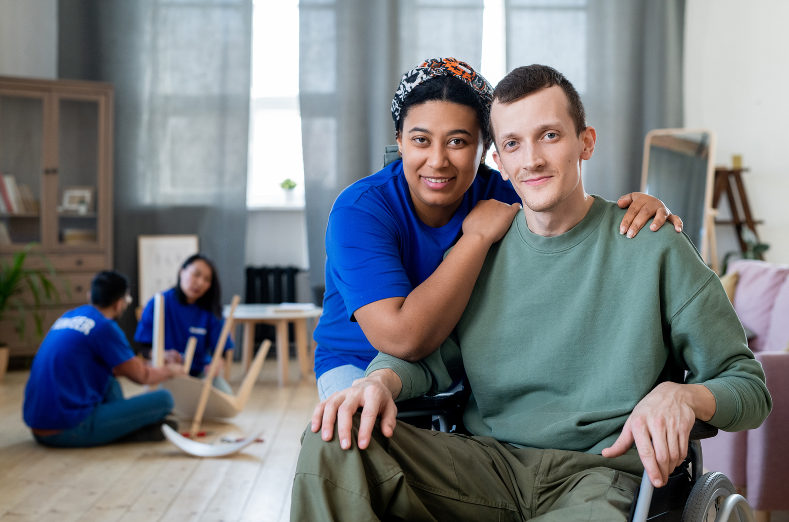 A carer assists a person with a disability in a wheelchair, illustrating what is an NDIS service provider and how they offer personalized support and care for individuals with disabilities.